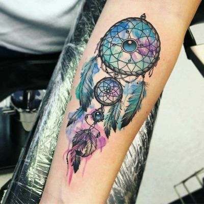  Tatouage attrape rêve en bleu et mauve sur l'avant bras